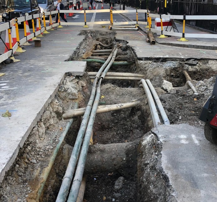Road works in a London street showing pipes and cables