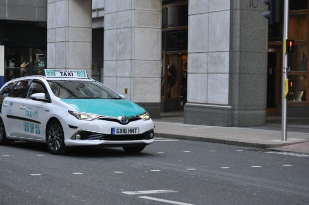 Blue and white taxi on the road